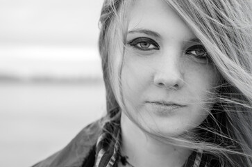 Young woman with long, light hair gazes intently ahead. Black and white toning emphasizes...