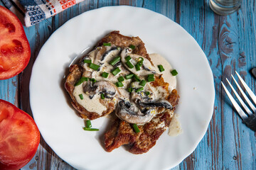 Pan seared pork steak on a wooden table with white sauce,pork fillet with dressing..