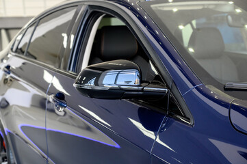 Fototapeta premium Front of new blue modern car in showroom close-up.