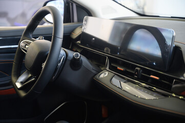 Modern car interior with black steering wheel, digital instrument panel