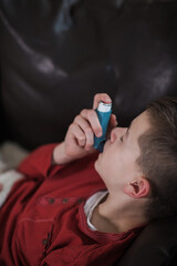 Pediatric asthma – little boy with inhaler at home