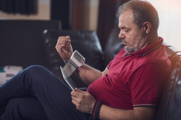Middle-aged man measuring blood pressure at home