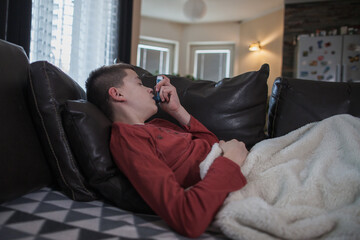 Pediatric asthma – little boy with inhaler at home