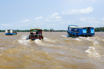 Traditional wooden tourist ferries traffic in the Mekong delta, Vietnam