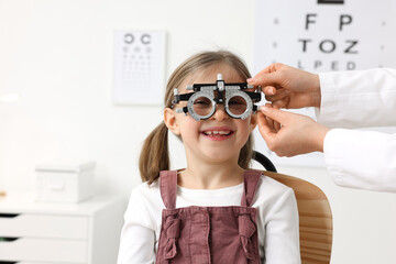 Ophthalmologist examining patient's vision with trial frame in clinic, closeup