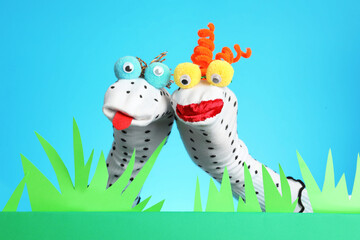 Creative puppet show on stage with decorations against light blue background