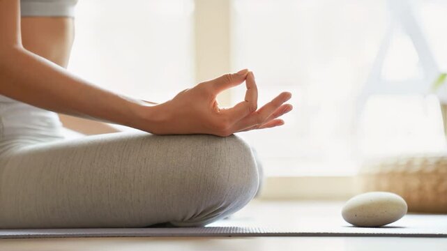 Zen Meditation 4K Video: Woman's hand close-up in Gyan mudra during yoga practice on mat. Achieving inner peace, mindfulness & spiritual wellness footage.