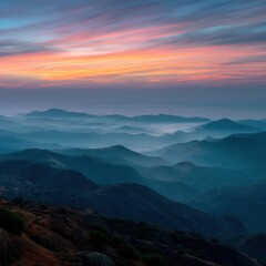 Fototapeta premium A serene mountain landscape at dawn, with mist covering the valleys and a colorful sky. 
