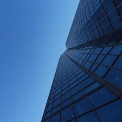 Fototapeta premium A tall skyscraper reaches towards a clear, vibrant blue sky, showcasing its modern glass exterior.