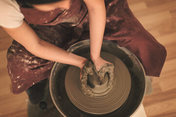 Pottery artist making a shape from clay. Shallow DOF. Developed from RAW; retouched with special care and attention; Small amount of grain added for best final impression. 