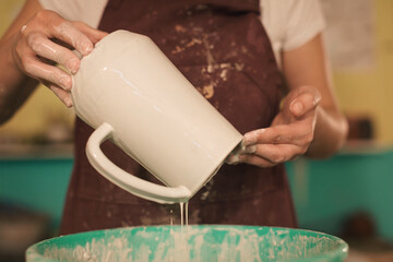 Pottery artist making a shape from clay. Shallow DOF. Developed from RAW; retouched with special care and attention; Small amount of grain added for best final impression. 
