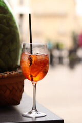 Aperol Spritz. Cold refreshing alcoholic cocktail Aperol Spritz. Cocktail close-up on a blurred background. Alcoholic drink in a glass with a straw. Traditional Italian alcoholic refreshing drink