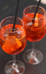 Aperol Spritz. Cold refreshing alcoholic cocktail Aperol Spritz. Cocktail close-up on a blurred background. Alcoholic drink in a glass with a straw. Traditional Italian alcoholic refreshing drink