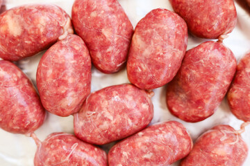 Freshly made sausages arranged neatly on a clean surface for culinary preparation