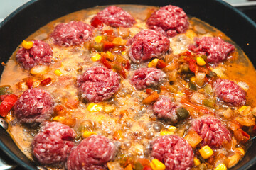 Delicious meatballs simmering in a rich tomato sauce with colorful vegetables