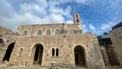 Fototapeta premium Historic Stone Church Facade With Bell Tower Under Cloudy Sky In Turkey, Daytime, Byzantine Architecture, Ideal For Travel, Cultural Heritage, Religious Tourism, Architecture Blogs, And Education