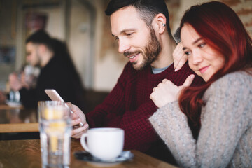 Young couple having coffee and using smart phone