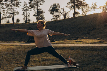 Young woman practicing yoga on nature. Girl meditating outdoors. Female with slim, strength and...