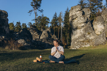 Young woman practicing yoga on nature. Girl meditating outdoors. Female with slim, strength and...