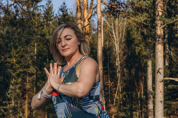 Fit sporty happy young woman wearing sportswear meditating doing yoga breathing stretching...