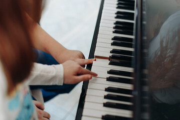 Fototapeta premium children try to play piano, cropped, unrecognizable, kids fun