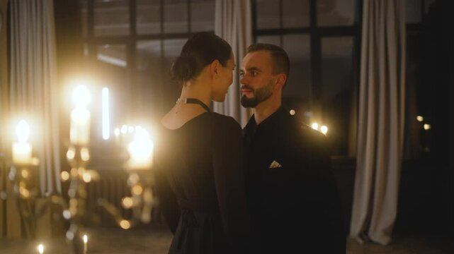 Professional dancers gracefully performing tango in a dimly lit ballroom, illuminated by the warm glow of candles