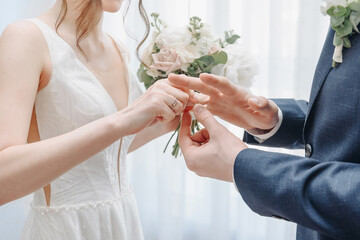 groom putting wedding ring on bride finger at ceremony in wedding day