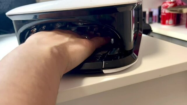 Beautician removing semi-permanent nail polish with uv lamp