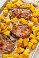 Pork chops and potatoes on a sheet pan oven roasted for an easy dinner