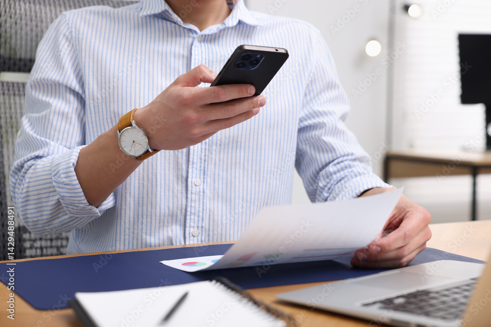 Poster man taking photo of document using scanning app on smartphone at desk in office, closeup
