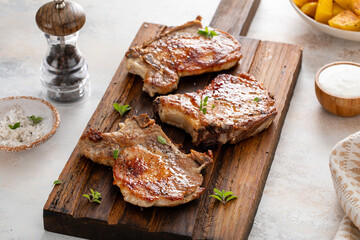 Pork chops grilled or seared on a wooden board