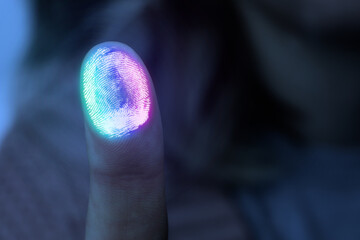 Colorful fingerprint remaining on surface while woman pressing her finger to scanner, closeup