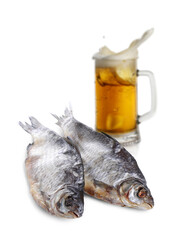 Beer splashing out of glass and dried fish on white background