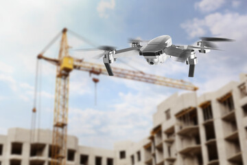 Drone with camera flying near unfinished building. Unmanned aerial vehicle for surveillance