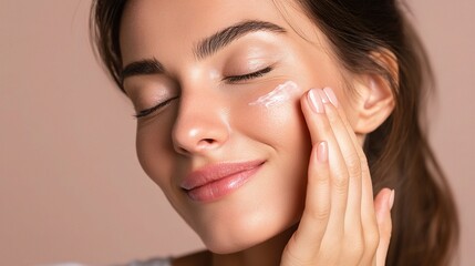Obraz premium Young Woman Applying Moisturizer with Eyes Closed for Skincare Routine