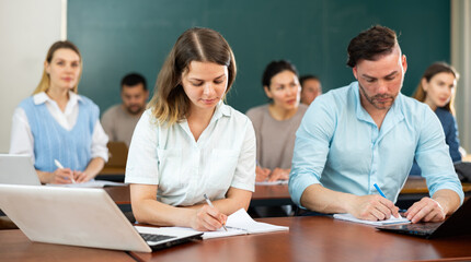 Portrait of attentive adult students on training session in auditorium