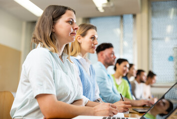 Side view of a group of adult students in university classroom