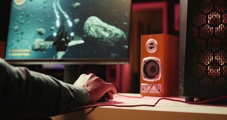 Man at home using cloud gaming service to play demanding science fiction videogame on PC. Gamer...