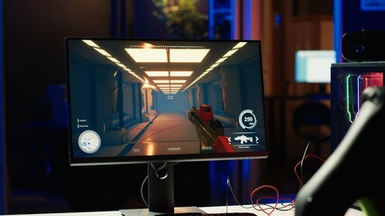 Shooting videogame on PC with neon lights illuminated components in empty apartment. Science...