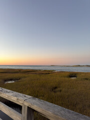 Sunset Over Coastal Marsh With Wooden Railing
