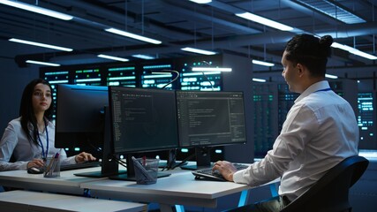 Engineers in high tech data center establishment installing software on computer, troubleshooting...