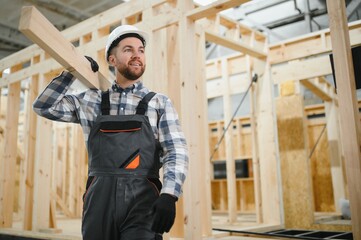 Modern modular house. A worker works on the construction of a wooden house