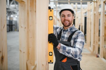 Modern modular house. A worker works on the construction of a wooden house