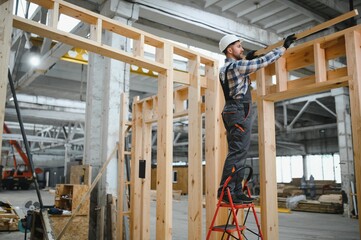 A carpenter works on the construction of modular houses
