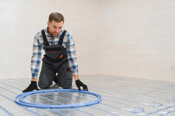 Water underfloor heating systems installation, work in progress on construction site for a modular...