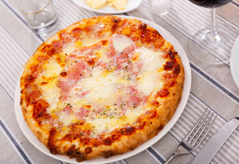 Freshly baked pizza with dried ham prosciutto, cheese and spices. Homemade food, traditional recipe, party snack
