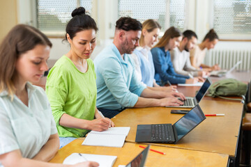Group adult students listening and writing during business course