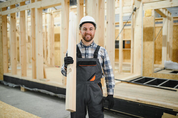 Worker carpenter assembling a modular house