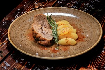 Appetizing Pieces of Meat with Mushrooms on a Stylish Plate, Garnished with Lettuce Leaves, Located on a Wooden Table, Creating an Attractive Image for a Restaurant Menu