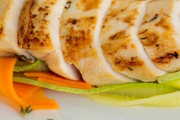 Appetizing Close-Up of Grilled Chicken Fillet with Vegetables, Highlighting the Juiciness of the Meat and Freshness of Ingredients.